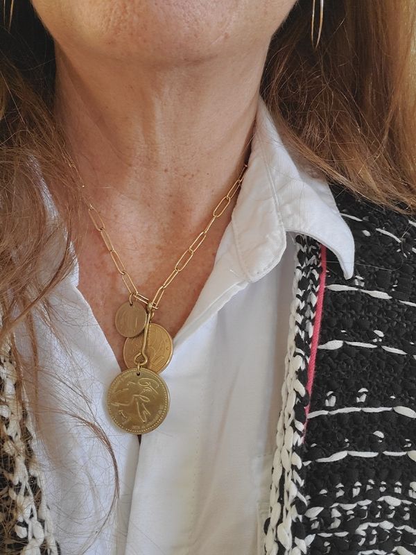 gold coin necklace worn with black and white