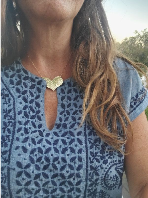 wearing a gold heart necklace