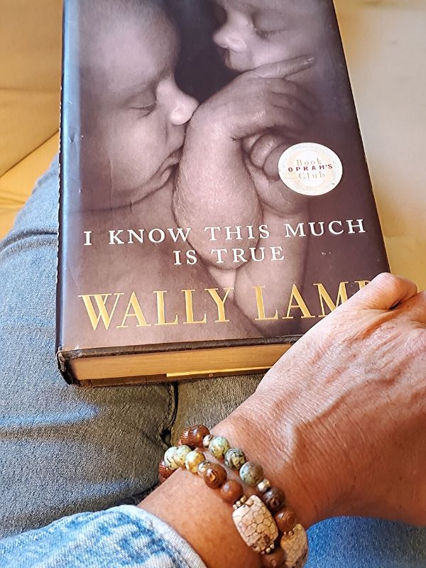 holding a book & wearing an earthy bracelet