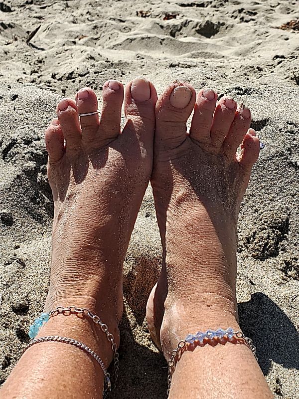 bare feet in the sand with anklets