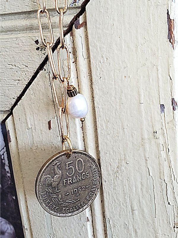 French coin necklace on distressed wood
