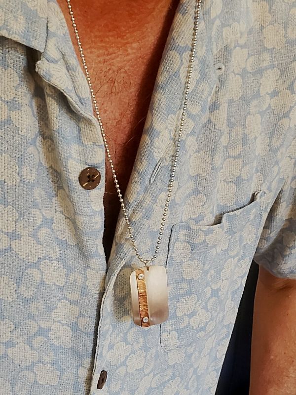 man wearing silver copper dog tag necklace