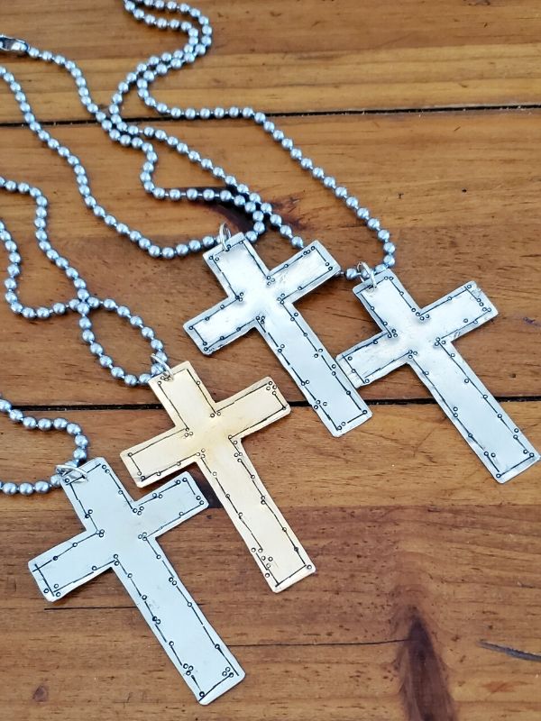 group of artsy cross necklaces in metal choices