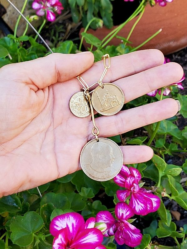 coin necklace in hand in the garden