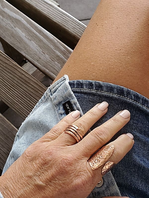 wearing denim and hammered copper rings