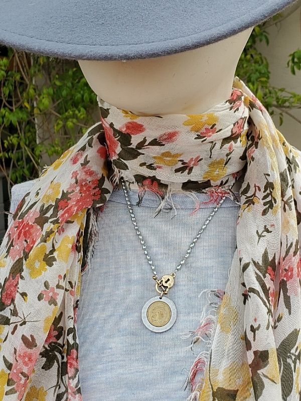 Flowered scarf and Italian coin necklace on mannequin