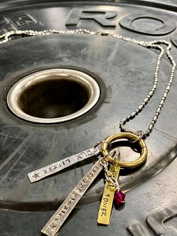 weight lifter charm necklace on a weight