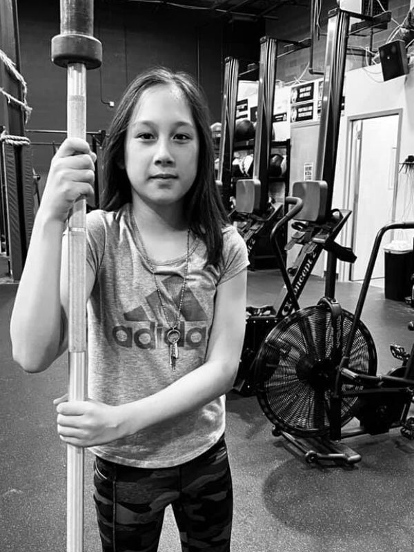 back & white photo of girl weight lifter wearing necklace