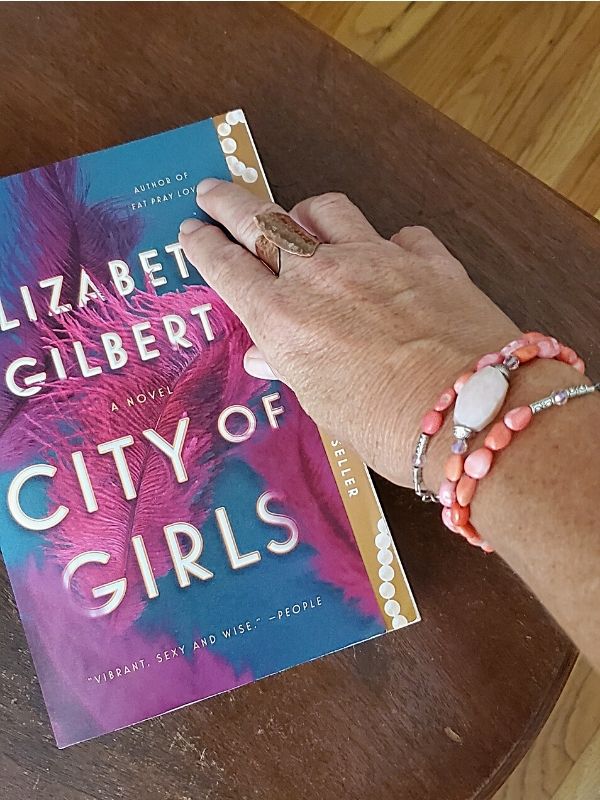 wearing a ring 7 pink bracelet with a book