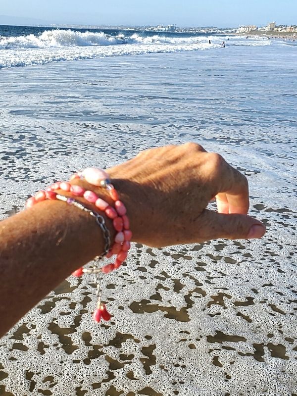 pink gemstone bracelet on arm at beach