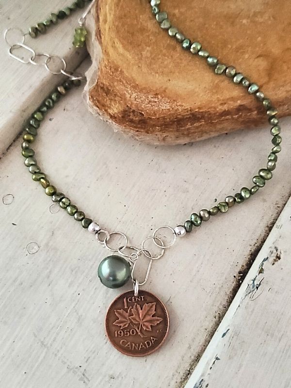 Green pearl Canada coin necklace on wood