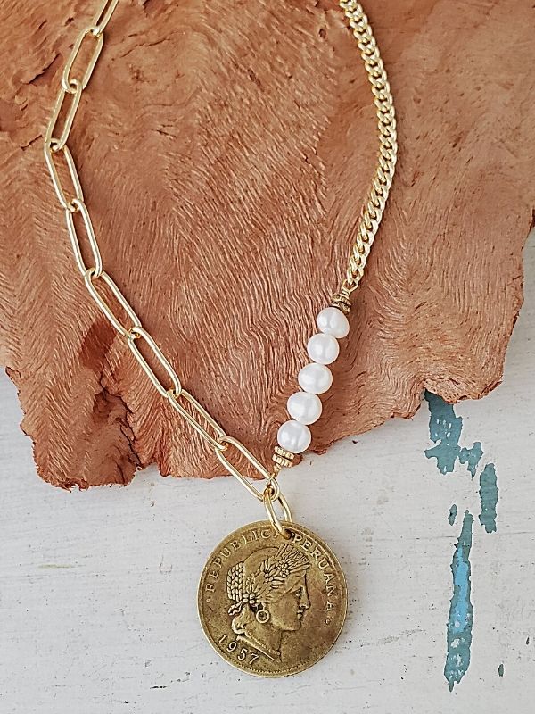 gold chain old coin necklace on wood & white trunk