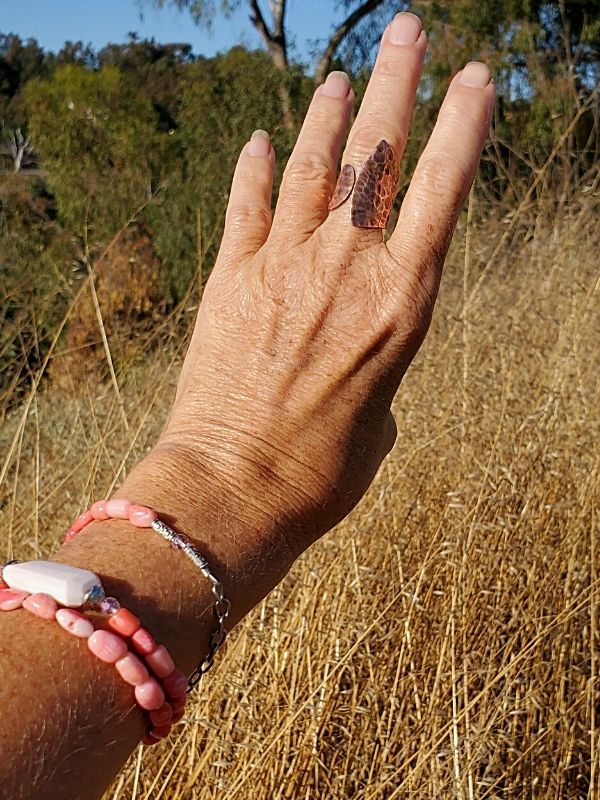 wearing pink gemstone bracelet in golden wheat field