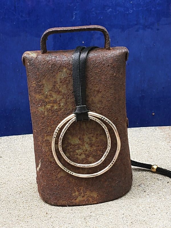 silver circle leather necklace on a cowbell