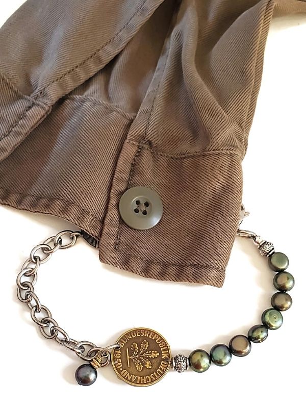 green jacket with old coin bracelet