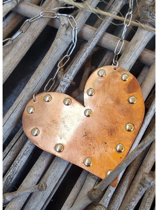 copper heart necklace on driftwood