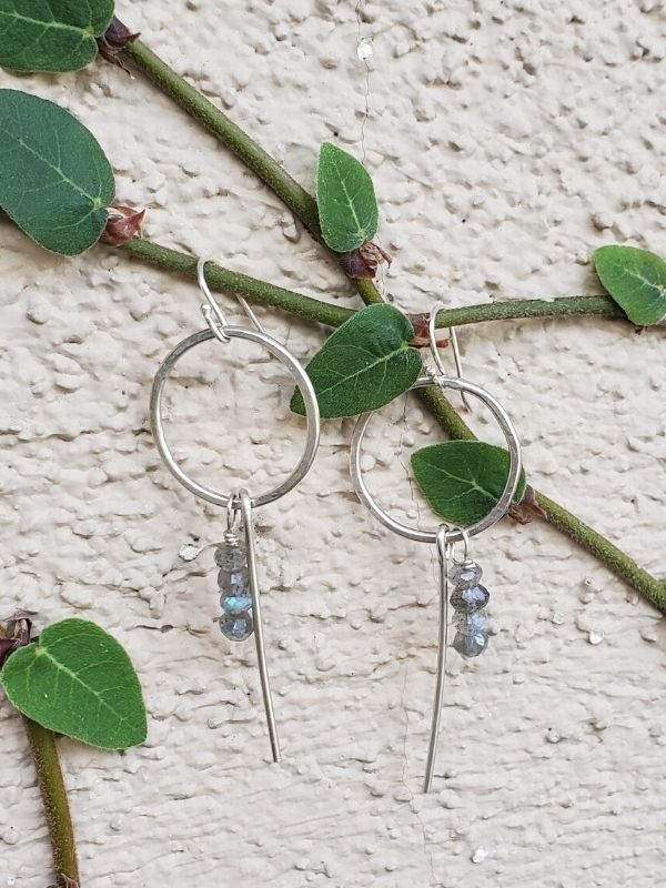 silver earrings hanging from a vine