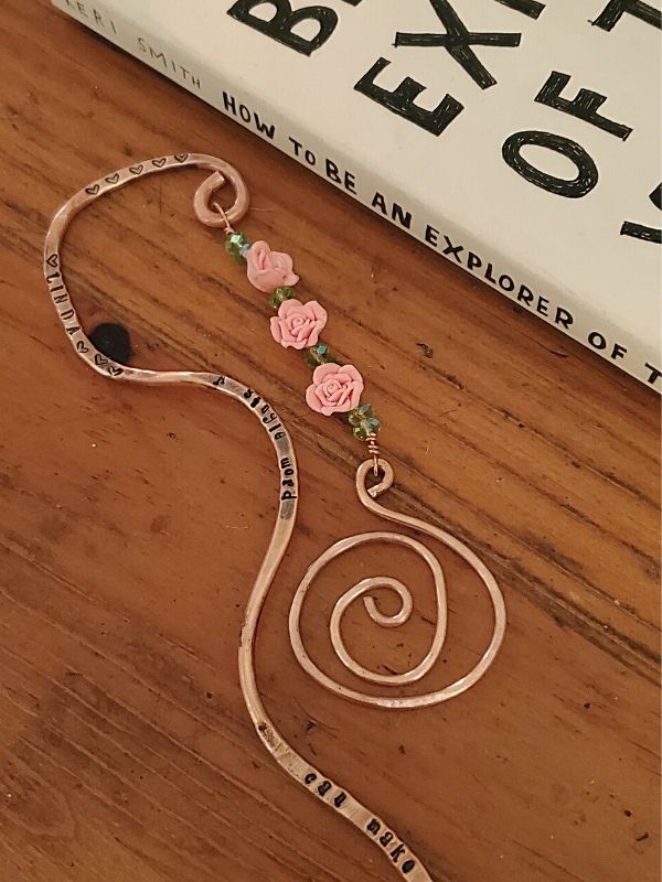 whimsical copper bookmark next to book