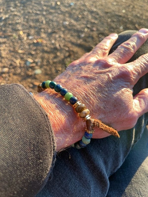 men's blue beaded bracelet with hand on knee