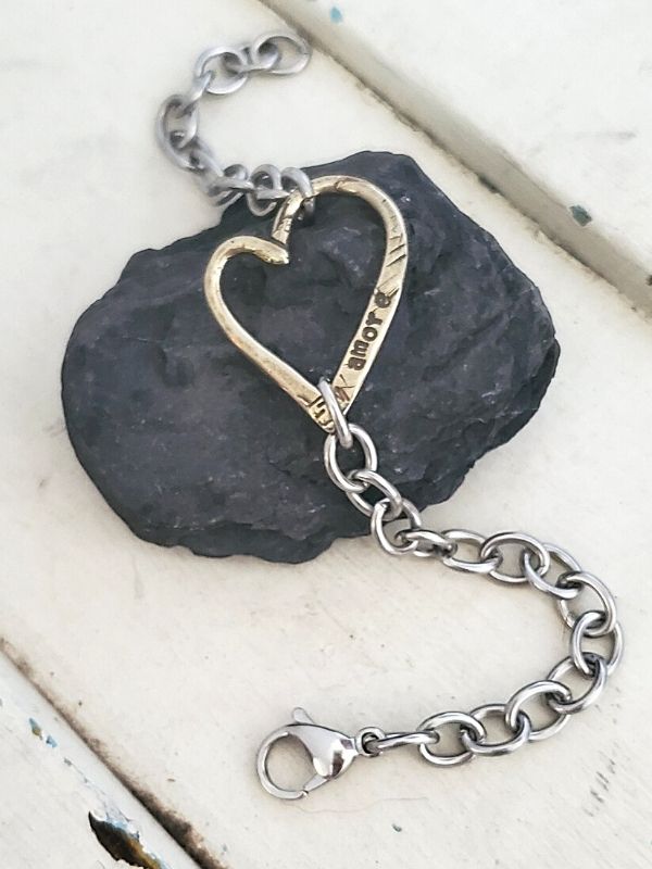 open heart chain bracelet on rock on trunk