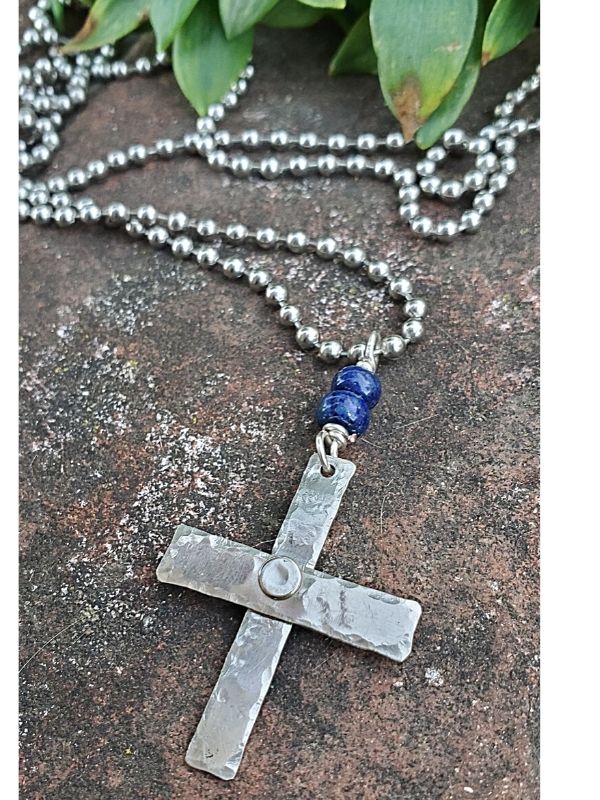 silver hammered cross necklace on brick