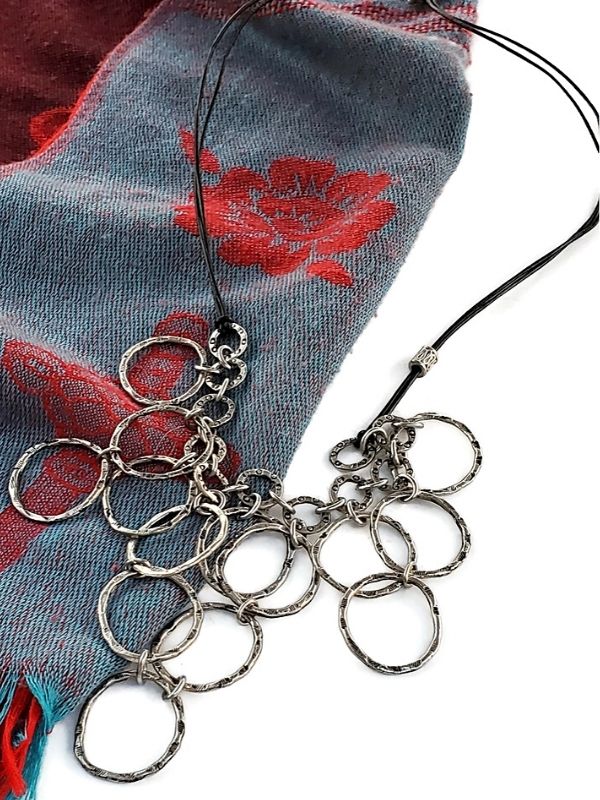 long silver bib necklace on a neck scarf