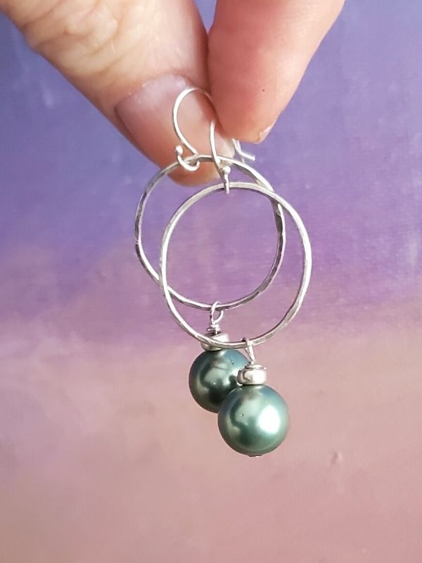 green pearl earrings against muted colors