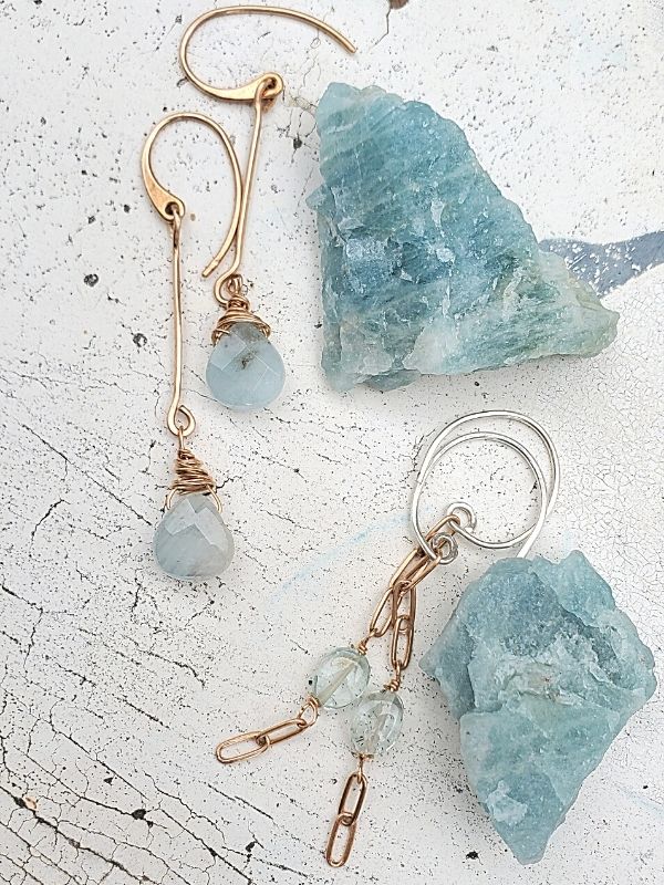 blue gemstone earrings on white distressed table