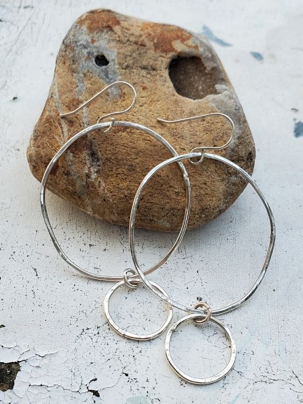 silver double hoop earrings on a rock
