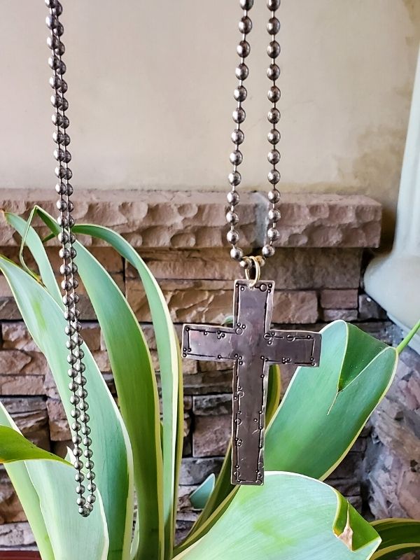 big artsy silver cross necklace with plant