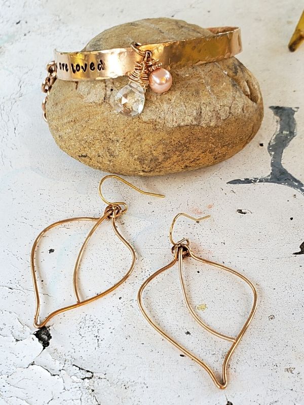 handcrafted bracelet & leaf earrings on white table