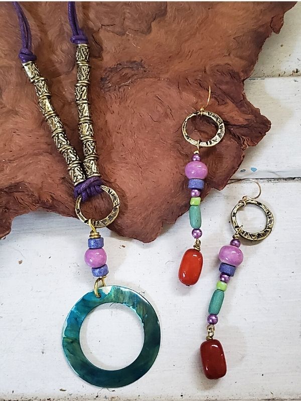 colorful beaded necklace earrings on wood