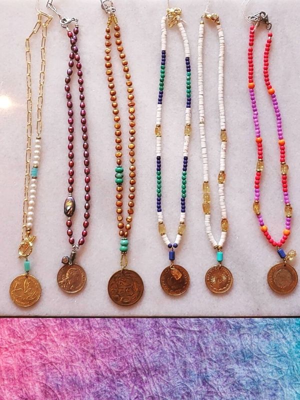 row of colorful old coin necklaces