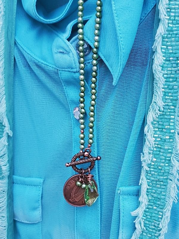 teal shirt with green pearl Ireland coin necklace