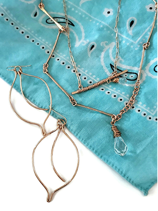 bronze bar necklace earring assortment on blue bandana