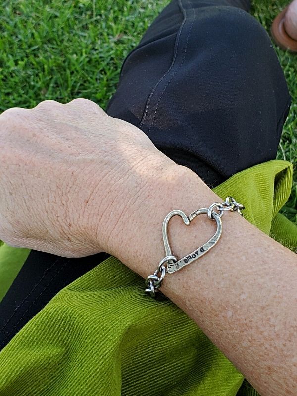 chunky silver heart bracelet on wrist