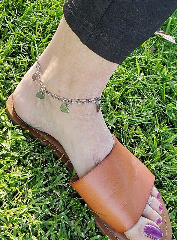 wearing silver heart anklet and leather sandals