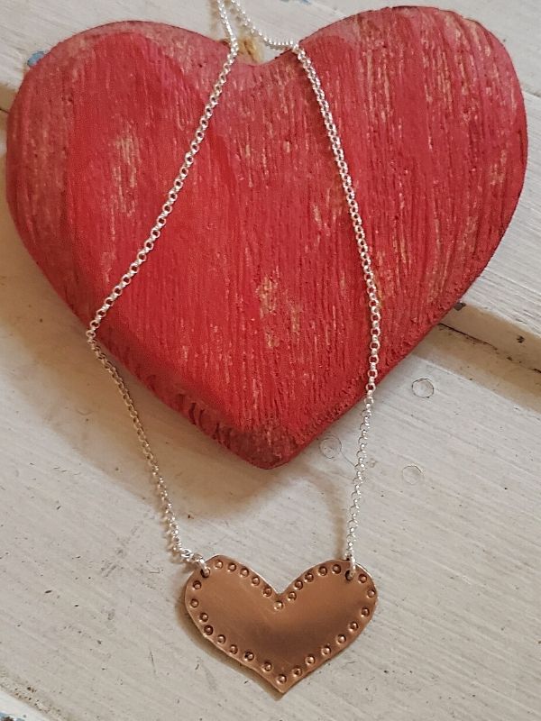 bronze dotted heart necklace on red wood heart
