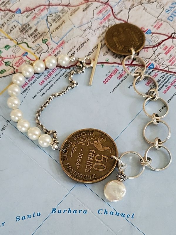 old coin bracelet on top of map