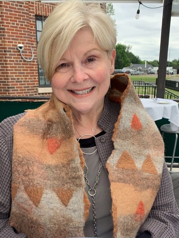 female wearing layered silver necklaces at dinner