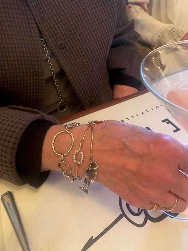 silver bracelet stack in wrist at restaurant