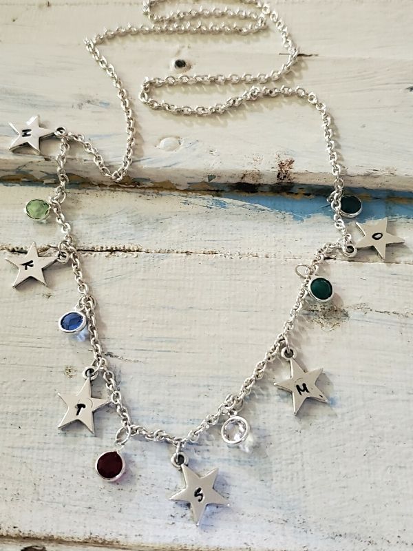 birthstone silver star necklace on white trunk