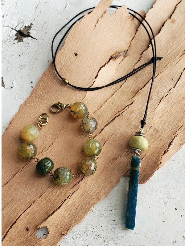 green gemstone necklace bracelet on wood