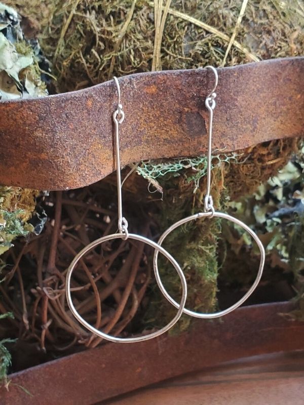 modern silver earrings on rusted bars