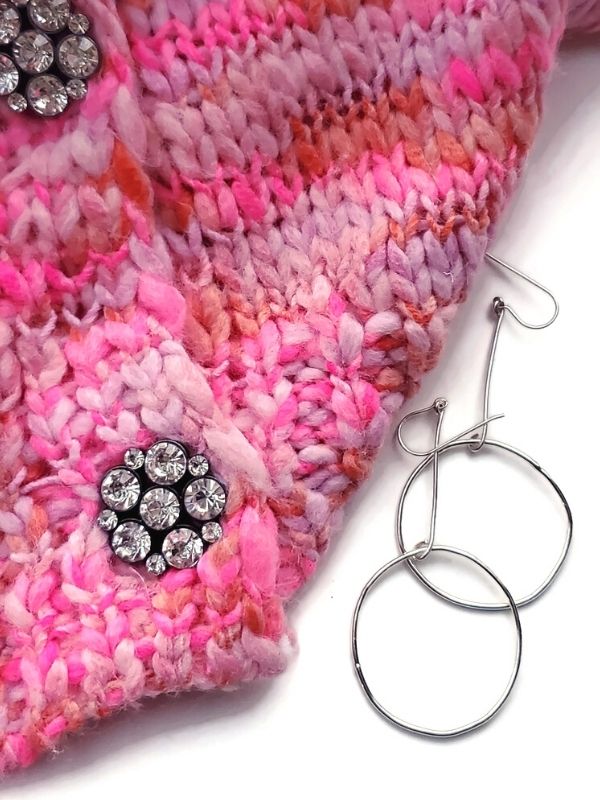 pink sweater with silver earrings