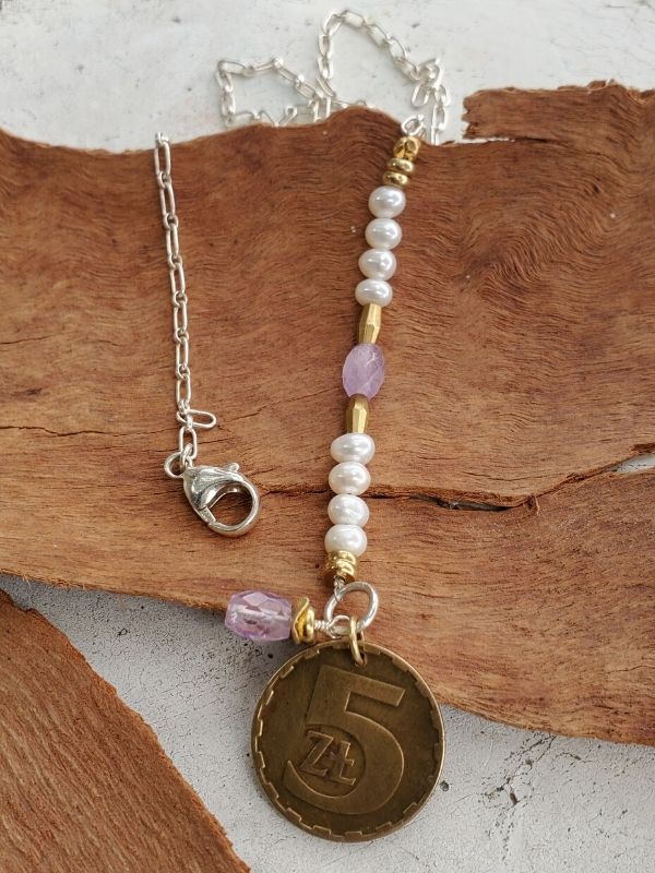Birthstone coin necklace on wood