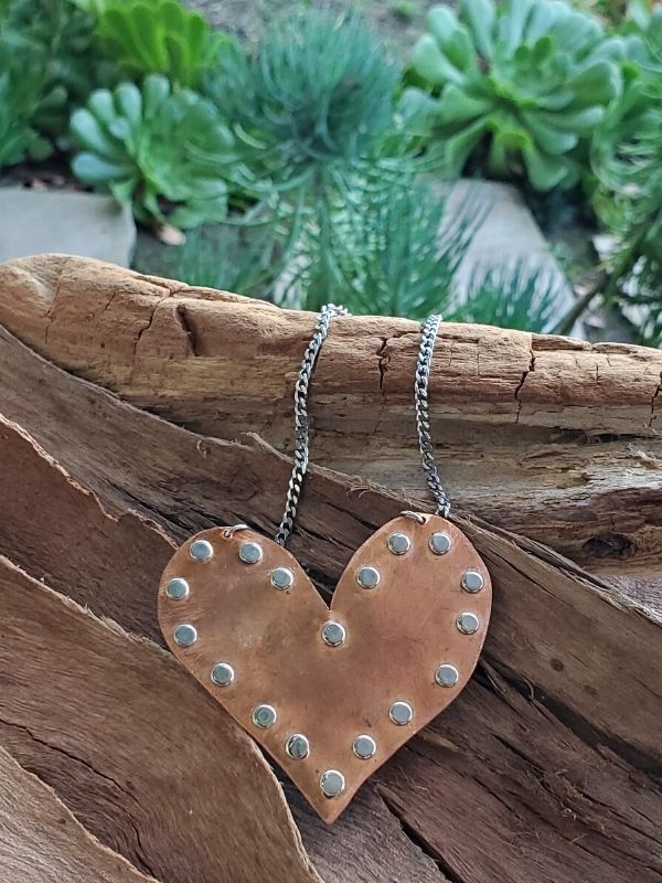 copper heart necklace on wood in garden