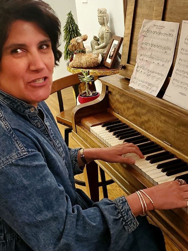 female playing piano with silver cuff stack