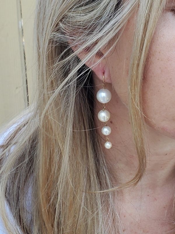 female profile with long pearl earrings