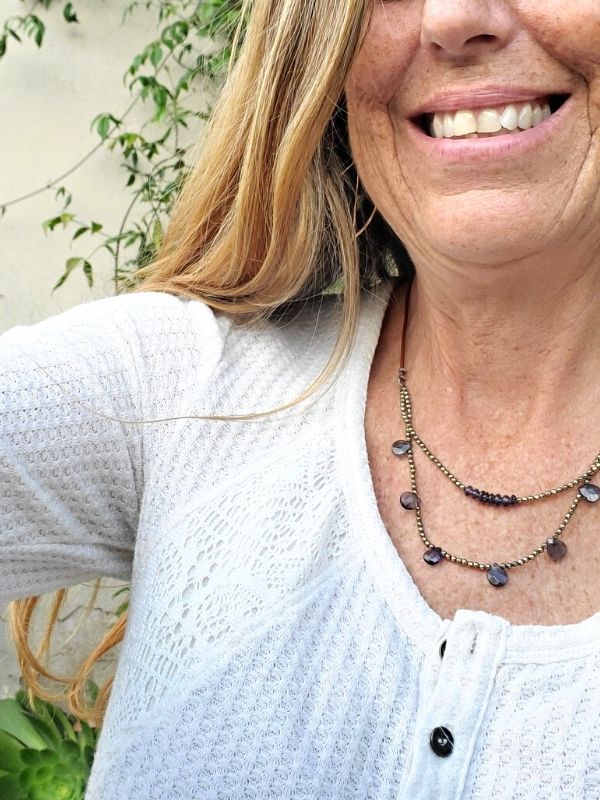 female wearing layered blue stone leather necklace